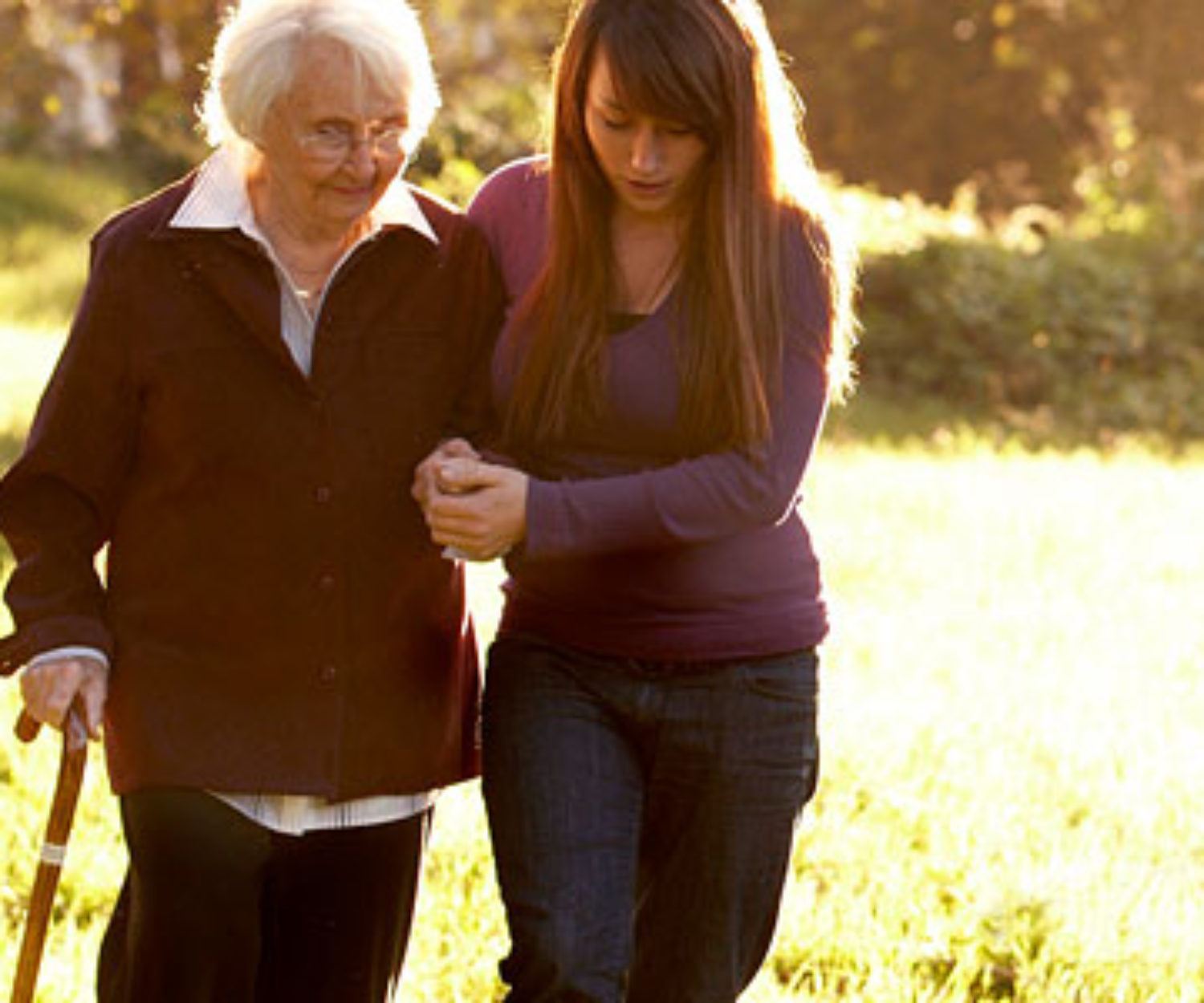 Young woman helping an elderly woman with a cane