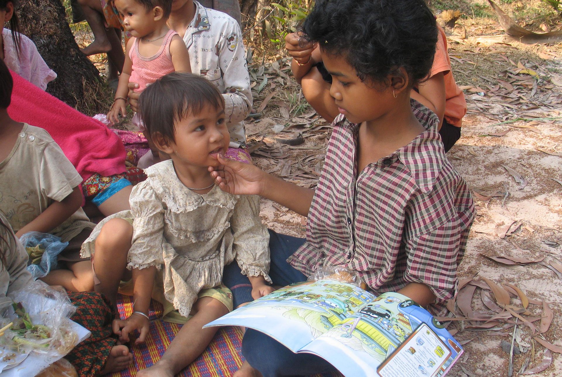 Indian children sitting outside reading